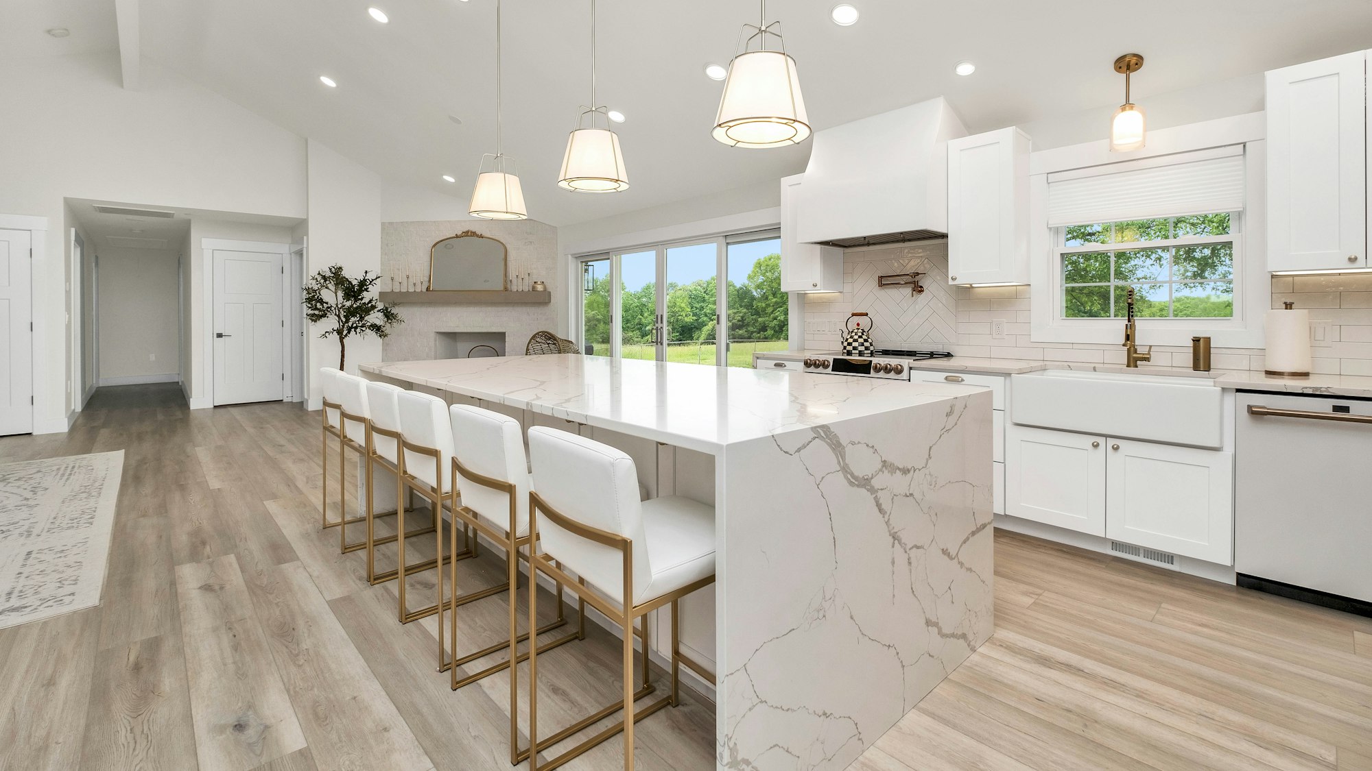 Renovated open-plan kitchen with a stone island bench and pale timber floors